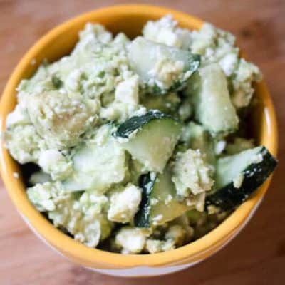 Avocado, cucumber, & feta salad in a yellow and white bowl