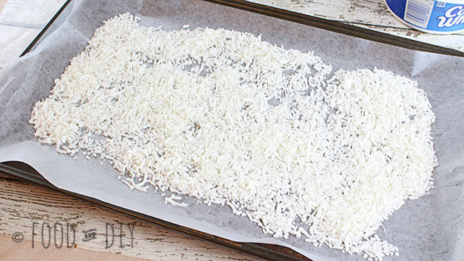 Shredded coconut on wax paper on a cookie sheet