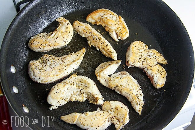 Chicken tenders cooking in olive oil in a skillet