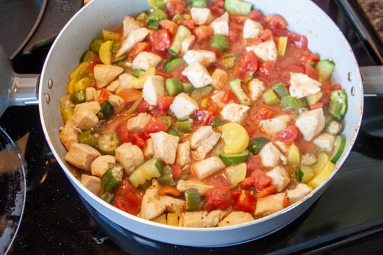 chicken, zucchini, okra, tomatoes and yellow squash in skillet