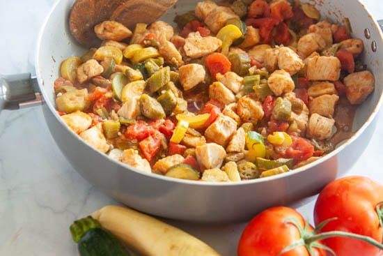 chicken, zucchini, okra, tomatoes and yellow squash in skillet